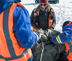 Casey research Station Leader, Rebecca Jeffcoat packing up the parachute from the airdrop