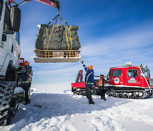 Casey research station expeditioners load the cargo from the airdrop onto a tracked