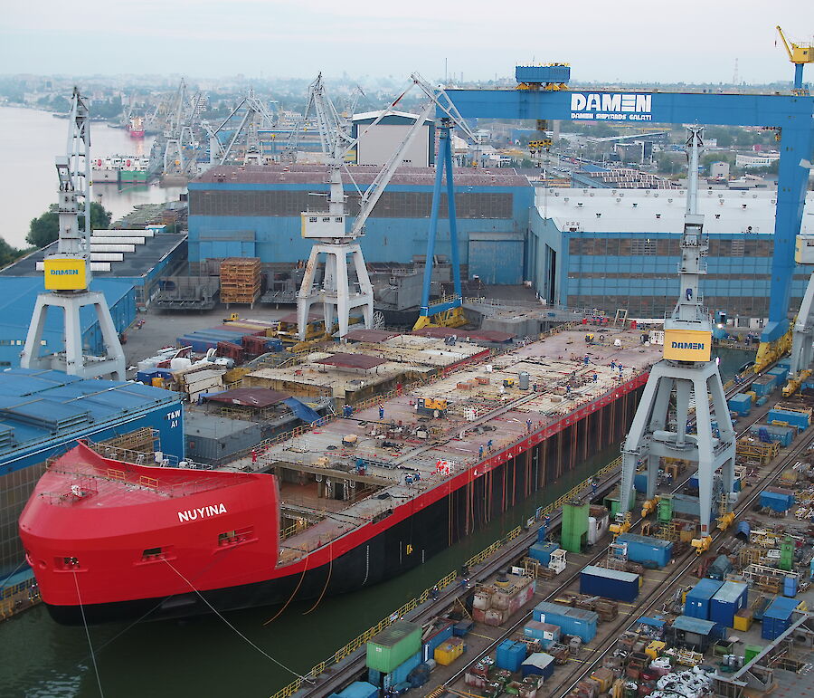 The RSV Nuyina floating in the dry dock with strops attached to buoyancy bags running down the ship’s sides.