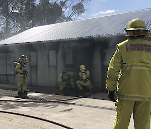 Expeditioners prepare to enter a burning building and retrieve a mock patient