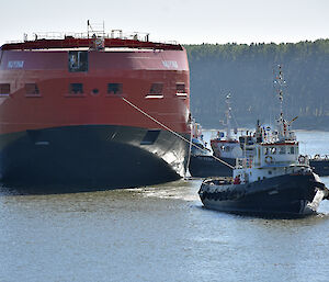 Three tugs position the ship for its return to the wet dock, bow first.