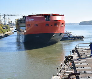 Ropes and tug boats help manoeuvre the ship into the correct position.