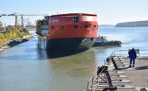 Ropes and tug boats help manoeuvre the ship into the correct position.