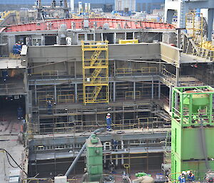 Scaffolding rising three decks in the forward cargo hold area.