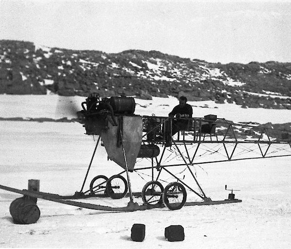 A black and white photo of a vintage aircraft frame in Antarctica.