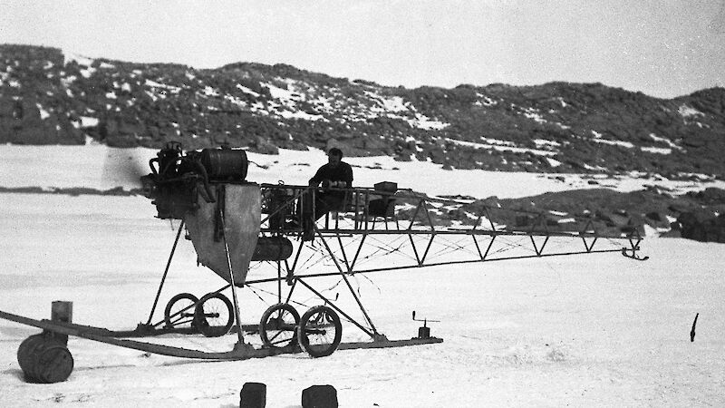 A black and white photo of a vintage aircraft frame in Antarctica.