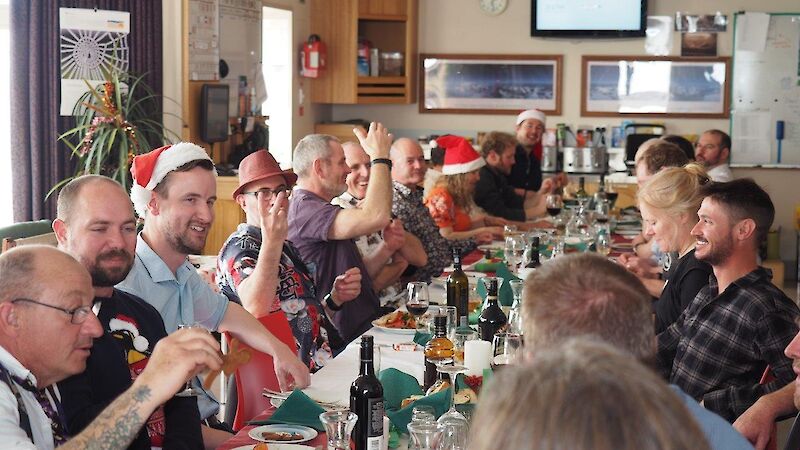 Expeditioners sitting around a table enjoying Christmas lunch