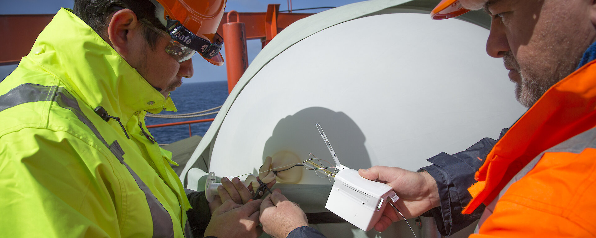 Juarez Viegas (left) and Jeff Aquilina from the US Atmospheric Radiation Measurement program prepare a radiosonde for launch.