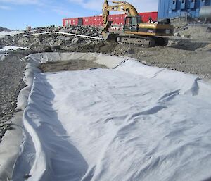 Excavated contaminated soil being placed inside the biopile containment cell.