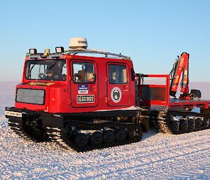 Red Hägglunds with trailer, parked on the ice