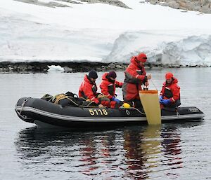 Four scientists working from a boat collecting samples