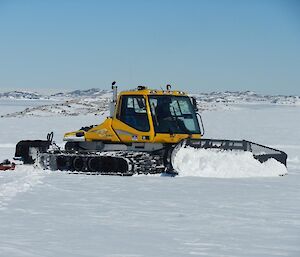 Yellow grader smooths the ice as skiway preparation