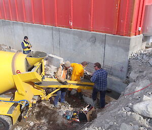 Placing the first concrete pad footing in the northwest corner. Andrew Fitzsimmons on the vibrator, Paul Tuplin on the shovel, Mick Denny on the shoot & Jan Adolf from AAD HO in the background