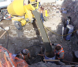 Pouring concrete into the pier forming tubes. Mick Denny by the truck, Brad Robson on the left and Paul Tuplin guiding in the concrete