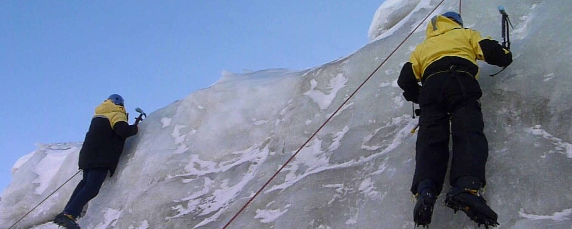 Two expeditioners near the top of an ice cliff
