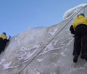 Two expeditioners near the top of an ice cliff