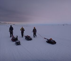Craig, Misty and Gav from behind, pulling sleds, as the sky darkens