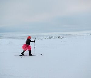Relay for Life expeditioner on skis and dressed in pink