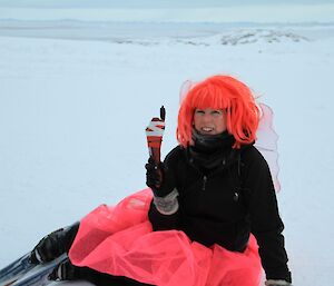 Relay for Life. Misty poses in pink wig and tutu on the ice