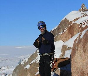 Phill Marthick in climbing gear surrounded by ice and rocks