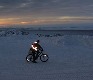 Mike on his push bike outside on the ice with reflective vest