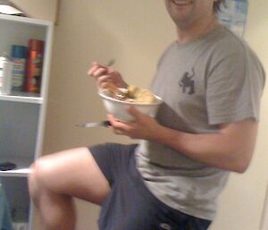 Dan exercising on stationary bike while eating from a bowl