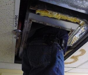 Phill fixing a humidifier in the ceiling