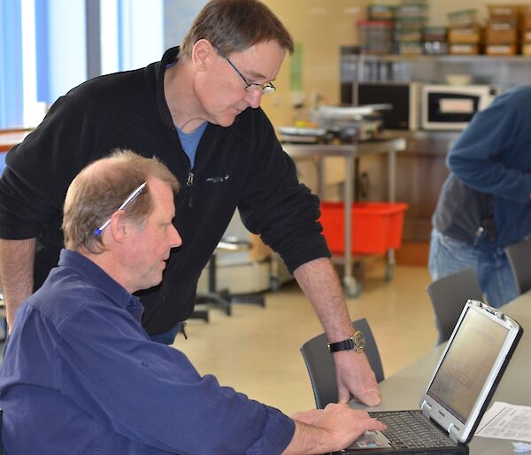 Dave and Andy looking at maps on a laptop