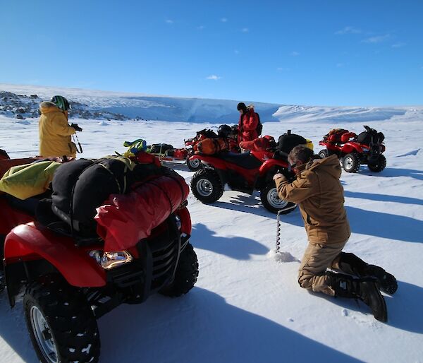 Drilling sea ice for quad travel