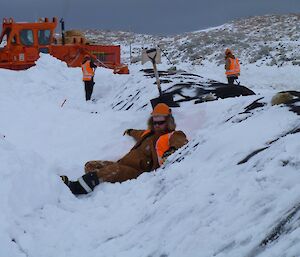 Dan at the biopile site lying in the snow