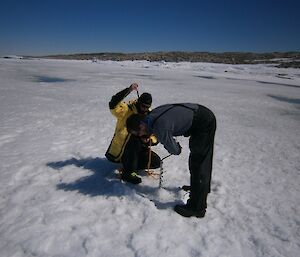 Drilling the sea ice on the way to Shirley Island to test the depth