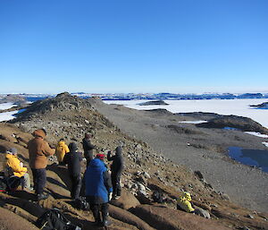Expeditioners on top of a rocky hill taking in the views