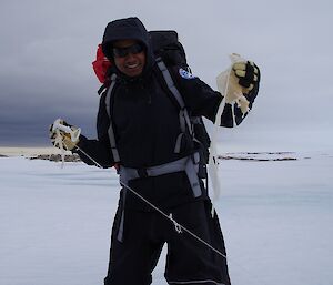 Abrar holds a found weather balloon in the Antarctic