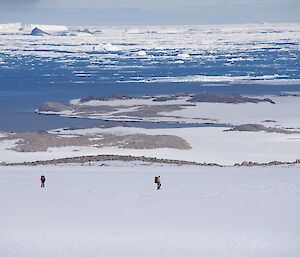 A landscape shows vast ice plains with three expeditioners looking for lost weather balloons