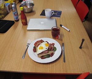 A breakfast dish of toast, eggs and bacon with salad