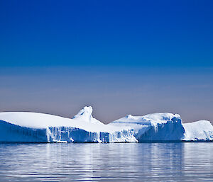 Large iceberg with four tiers surrounded by clear water