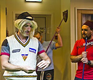 Lee, dressed in a blond mullet wig flipping a coin to decide which team to break in pool