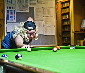 Scotty still wearing the mullet wig lining up for the shot in pool