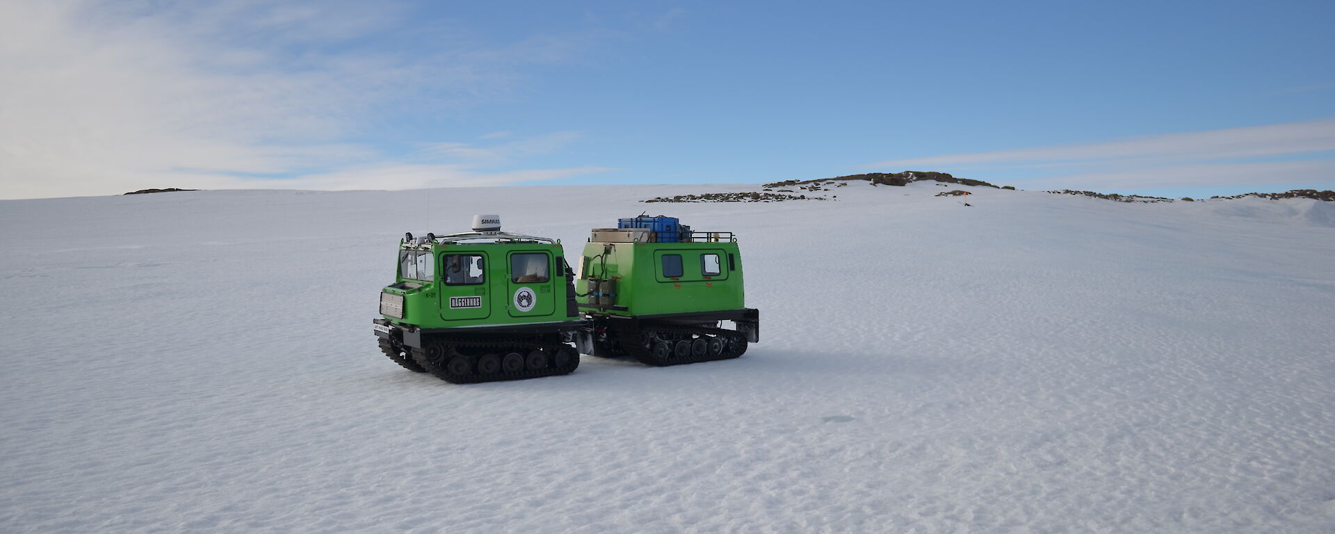 Picture of a green Hagglund on snow covered terrain