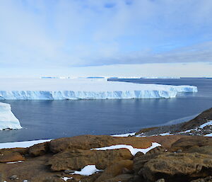 Vanderford Glacier meeting the ocean with rocky foreground