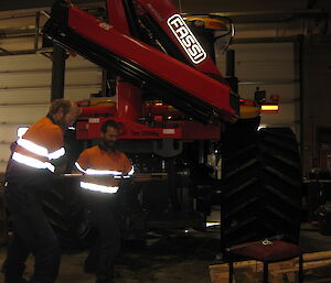 Matt and Mick installing a red crane on a large yellow Challenger truck