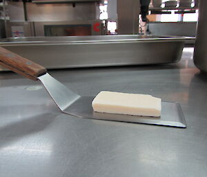 Picture of the first bar of soap in the kitchen, resting on a metal spatula