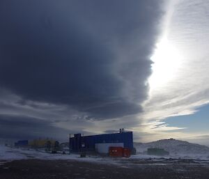 Thick layering cloud over a Casey building with drifting snow in the foreground