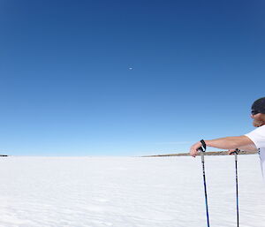Matty on skis in the foreground and a small speck of a commercial Qantas aircraft at 10,000ft