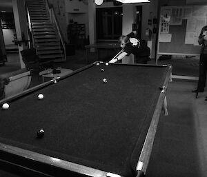 A black and white picture of Tim playing pool