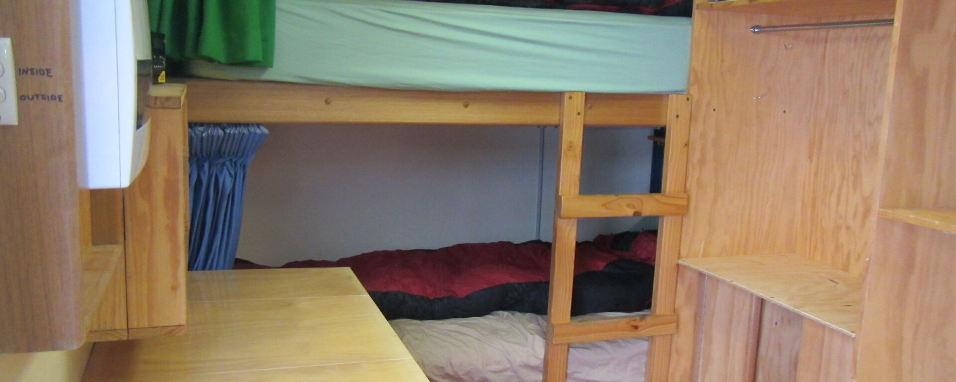 A small tight room with a bunk bed