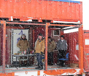 Picture of a few expeditioners in the verandah and BBQ area in a snowy day