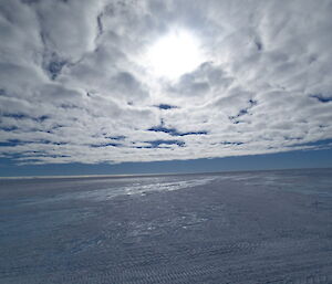Landscape shot of just a flat icy terrain and stratocumulus clouds