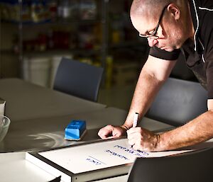 Scotty writing up the menu on a white board in the mess