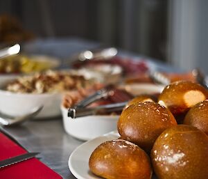 Picture of bread rolls with a blurry background of salad